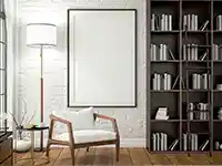 Ein Sessel steht neben einem Tisch und Bücherregal in einem hellen Zimmer.