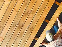 Eine Person verlegt Holzbretter.