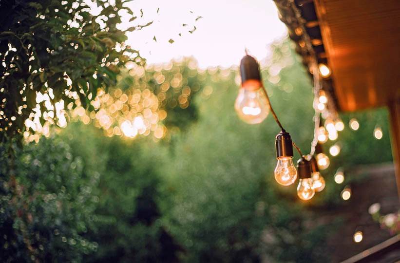 Solarlichterkette Glühbirnen die an einem Gartenhaus hängen 