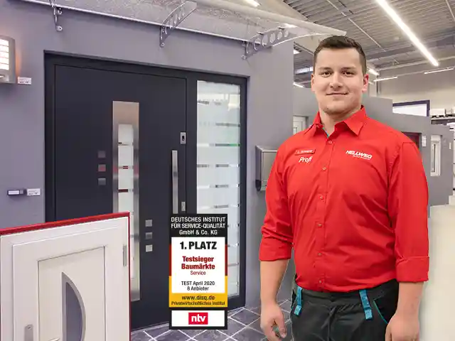 Ein Mann steht lächelnd vor den Türen eines HELLWEG Baumarkts.